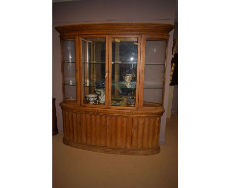 A 'Modern Century Furniture' glazed mirror back display cabinet, in light stained wood, the flared cornice above two glazed p