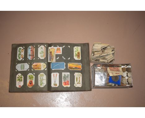 A tin of assorted coins; together with a cigarette card album; and a box loose cigarette cards.