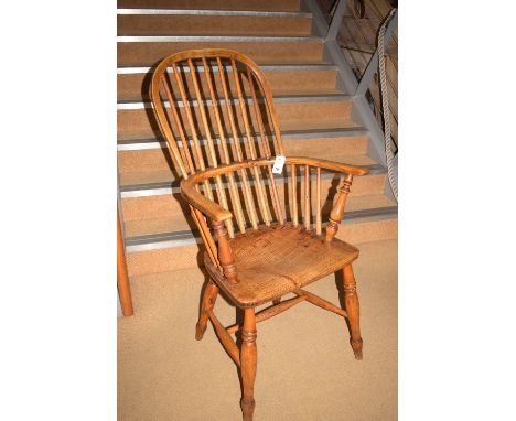 A 19th Century ash and elm seat Windsor comb back chair, raised on turned legs joined by stretchers.