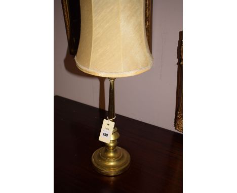 An early 20th Century brass table lamp on circular weighted base.