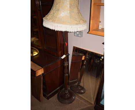 A turned stained wood standard lamp with floral decorated shade.