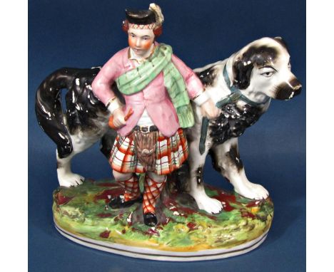 A 19th century Staffordshire group, a highlander in kilt and sash holding the lead of a large black and white dog 