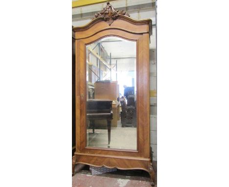 A walnut veneered armoire, the single mirror panelled door with bevelled edge plate set within chevron banded borders beneath