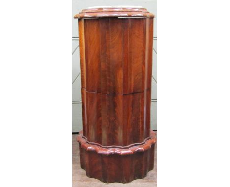 A good quality Victorian mahogany cylindrical commode with fluted outline, rising lid and opening arms enclosing the original