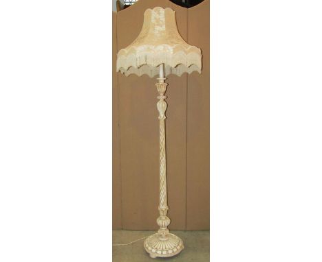 A painted wooden standard lamp with spiral fluted stem and foliate detail raised on a disc shaped platform and bun feet, toge