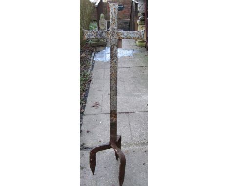 An old weathered wrought iron ecclesiastical cross raised on tripod stake supports, 130 cm high approximately 