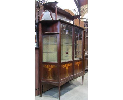 An Art Nouveau mahogany breakfront display cabinet, freestanding and enclosed by a pair of rectangular doors partially enclos