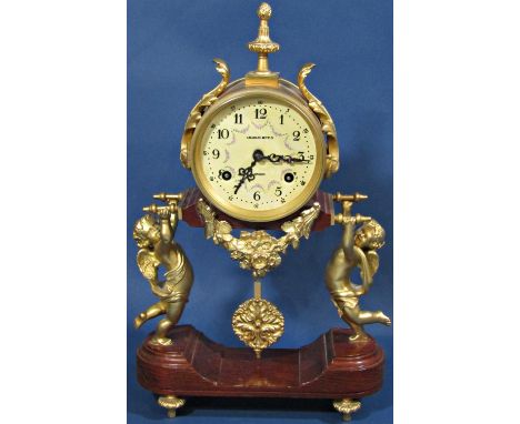 A contemporary mantle clock, the movement held aloft by two cherubs, with painted dial - Charles Beyfus of London, with pendu