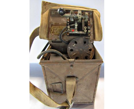 A WWII Morse Code signalling lamp held in a metal twin hinged box with canvas cover and strap. 