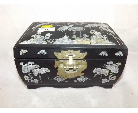 An Oriental jewellery box inlaid with mother of pearl and brass lock detail in the form of a fish 