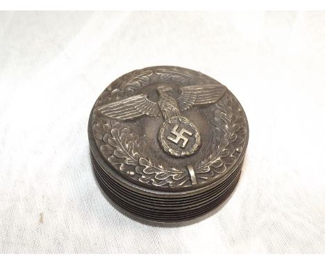 A round lidded snuff box with Swastika, Eagle and Wreath decoration to the lid 