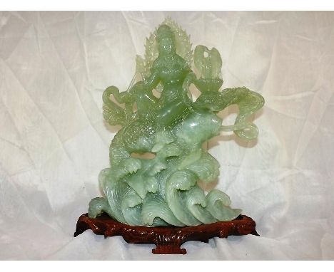 A Chinese jade celadon hard stone carving, mounted on wooden plinth, 33cm (h) with fitted box (2)