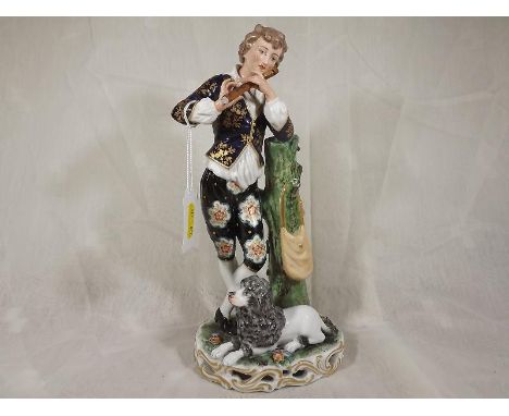 A 19th century French figure depicting a young man in period costume playing a pipe (end of pipe absent) with dog at his feet