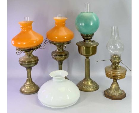 BRASS OIL LAMPS, A PAIR with circular bases, fluted columns, circular reservoirs, Duplex twin burners and orange opaque glass