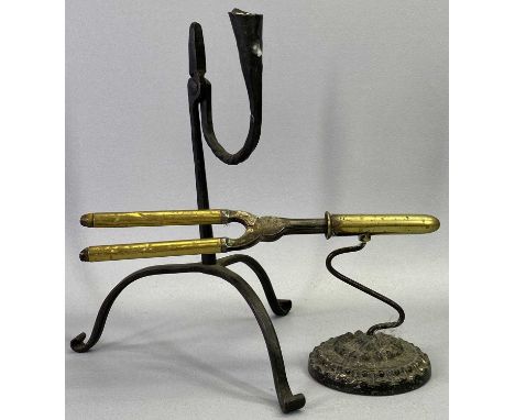 A STEEL RUSH LIGHT HOLDER - 19th century with candleholder to side and on tripod base with scroll terminals, 27cms H and a 19