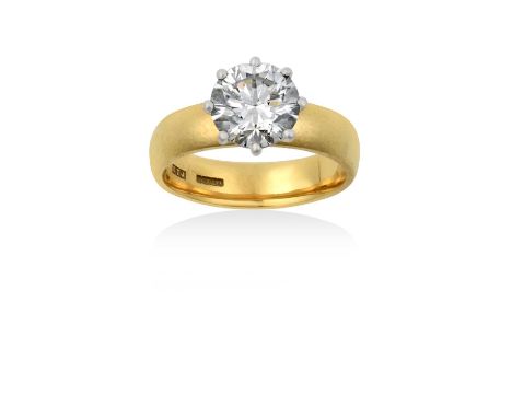 An 18 Carat Gold Diamond Solitaire Ringthe round brilliant cut diamond in a white claw setting, to a yellow plain polished sh