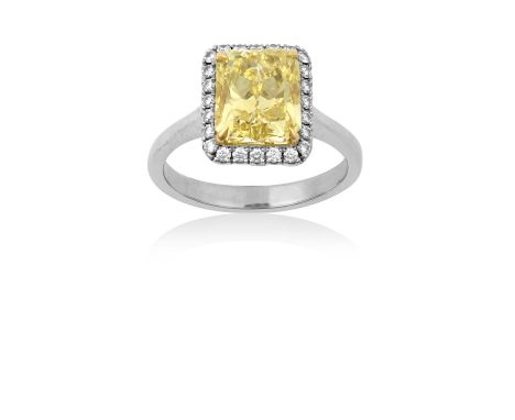 A Diamond Cluster Ring the fancy intense yellow cut-cornered rectangular modified brilliant cut diamond in a yellow four claw