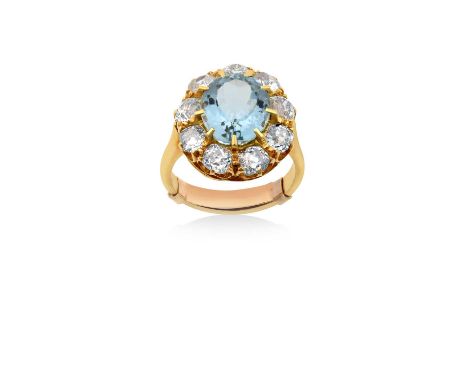 An 18 Carat Gold Aquamarine and Diamond Cluster Ringthe oval cut aquamarine within a border of old cut diamonds, in yellow cl