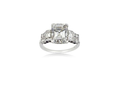 A Diamond Ringthe central emerald-cut diamond flanked by step cut diamonds, in white claw settings, to old cut diamond set sh