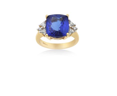 An 18 Carat Gold Tanzanite and Diamond Ringthe cushion cut tanzanite in a yellow four claw setting, flanked by pairs of trill