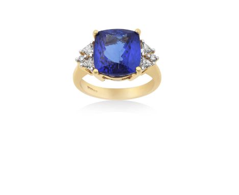 An 18 Carat Gold Tanzanite and Diamond Ringthe cushion cut tanzanite in a yellow four claw setting, flanked by pairs of trill