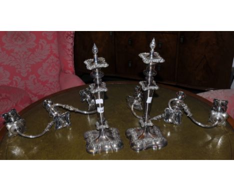 A pair of table candlesticks, campana shaped sconces, tapering cylindrical columns, spreading shaped square bases;  a pair of