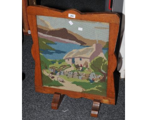 A mahogany firescreen, woolwork panel, 'Lakeside Cottage'