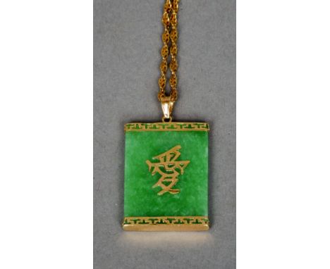 A 14 ct gold mounted apple green jade pendant
With applied Chinese character and 14 ct gold chain.  The pendant 3.5 cm high. 