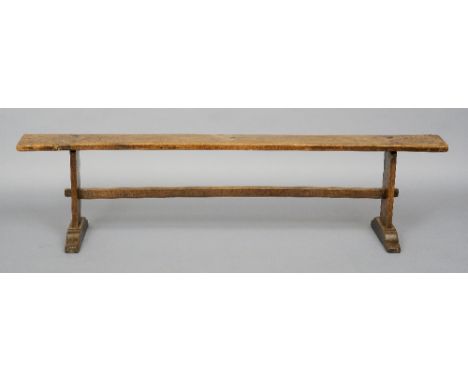 A 19th century fruitwood bench
The single plank top on end trestle support united with a stretcher.  190 cm wide. CONDITION R