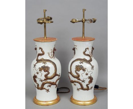 A pair of Chinese porcelain vases
Each with applied dragons, chasing a flaming pearl, adapted as lamp bases.  68 cm high over