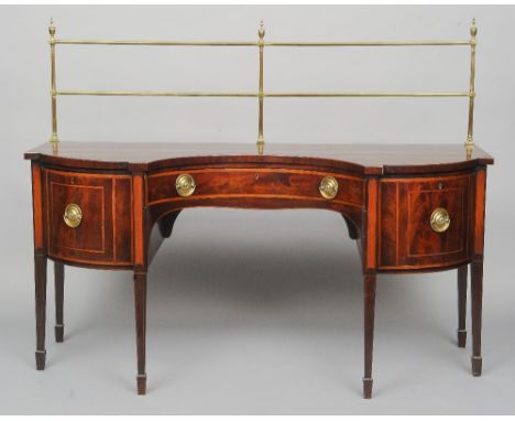 A George III mahogany inverted bow front sideboard
The shaped crossbanded top with a tubular brass gallery over three crossba