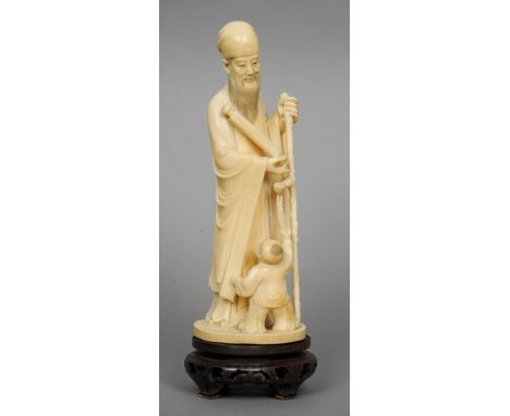 A 19th century Chinese carved ivory figural group
Formed as a sage holding a scroll, a small boy with flowers at his feet, mo