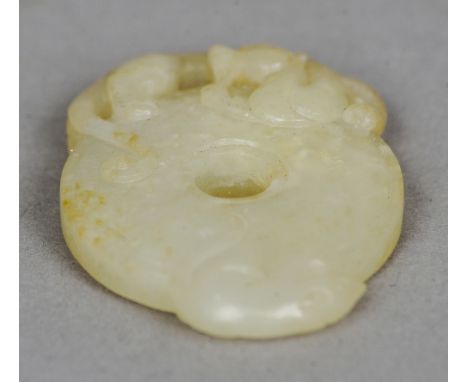 A Chinese carved jade bi disk
Surmounted with the figure of a dragon.  5.5 cm long. CONDITION REPORTS: Generally in good cond