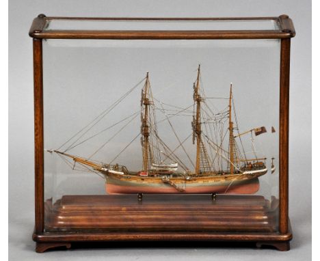 A small scale model of the three masted vessel Manila
Housed in mahogany framed bevel glazed display case.  The case 32.5 cm 