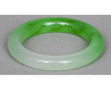A Chinese carved jade type bangle
Light green.  8.5 cm diameter. CONDITION REPORTS: Generally in good condition, expected wea