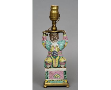 An 18th century Chinese famille verte porcelain figure
Modelled crouching in brightly coloured robes, with later brass plinth