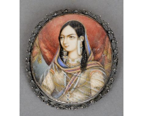 MUGHAL SCHOOL (19th century)
Portrait miniature of Maharani in Traditional Costume
In pierced white metal frame adapted as a 