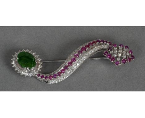An unmarked white gold, diamond, ruby and jade set brooch
Of pierced and scrolling form.  6 cm wide. CONDITION REPORTS: Overa