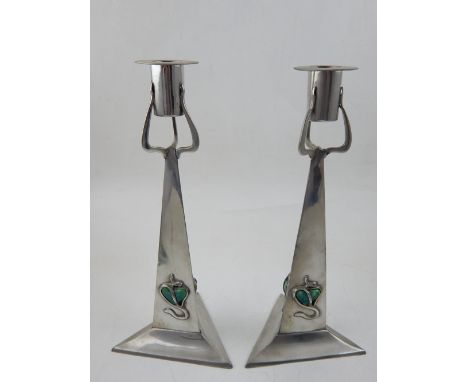 A pair of Art Nouveau style pewter candlesticks, the tapered triangular stems inset heart shaped enamel bosses. H. 25cm
