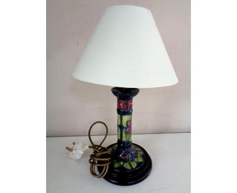 A Moorcroft table lamp, violets, on green ground, on wooden base, with shade 