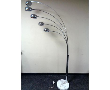 A contemporary chrome five way adjustable floor lamp on a circular marble base. 