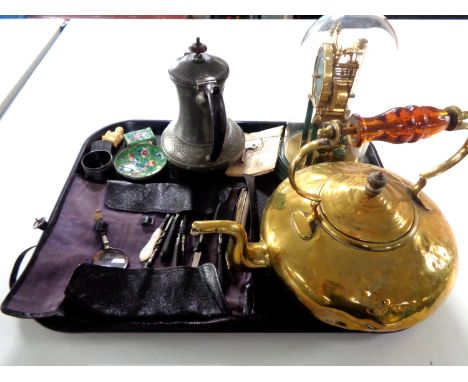 A tray containing antique pewter teapot, brass kettle, a Kundo anniversary clock under shade, cloisonne pin dish and matchbox