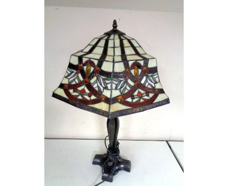 A cast iron table lamp together with a Tiffany style leaded glass shade.  