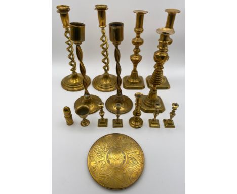 A collection of 19th century brass candlesticks, to include various pairs along with an engraved coaster, a miniature goblet,