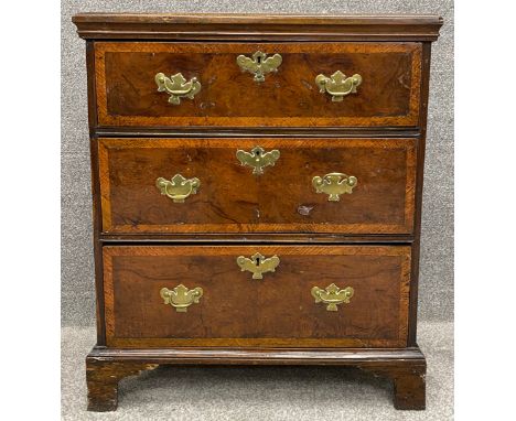 A small Georgian yewwood and crossbanded chest of drawers probably with original brassware raised on shaped bracket feet. H.8