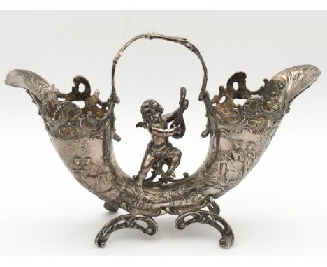 A hallmarked silver cornucopia epergne decorated with Rococo scrolls and a winged cherub playing a lute, London 1881. H.20 W.