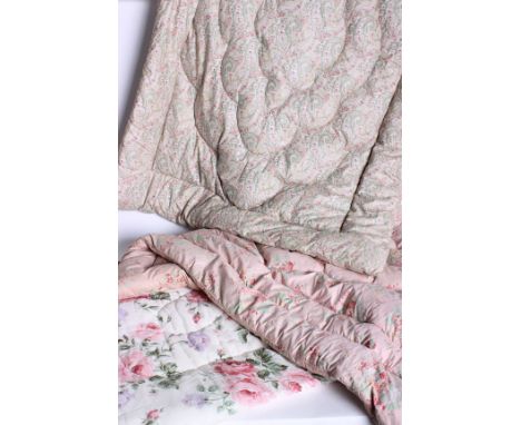 A 1930s single size feather eiderdown, decorated with clusters of flowers onto a pale pink background, a paisley print single