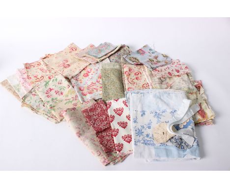 A collection of textiles and scraps suitable for patchwork and similar projects, including floral cotton fabrics, paisley pri