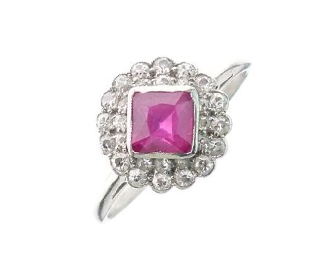 Dress ring set central square ruby coloured stone with diamond surround, with white metal shank (cut)   Condition: 