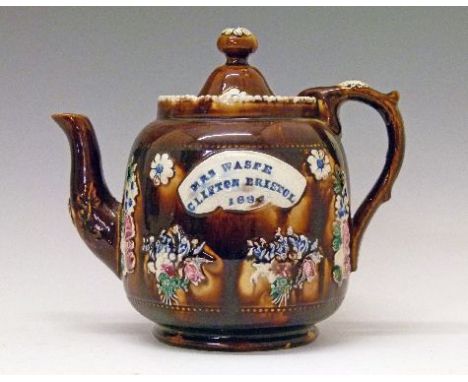 19th Century bargeware teapot having typical applied floral sprays on a brown mottled ground, with applied plaque with script